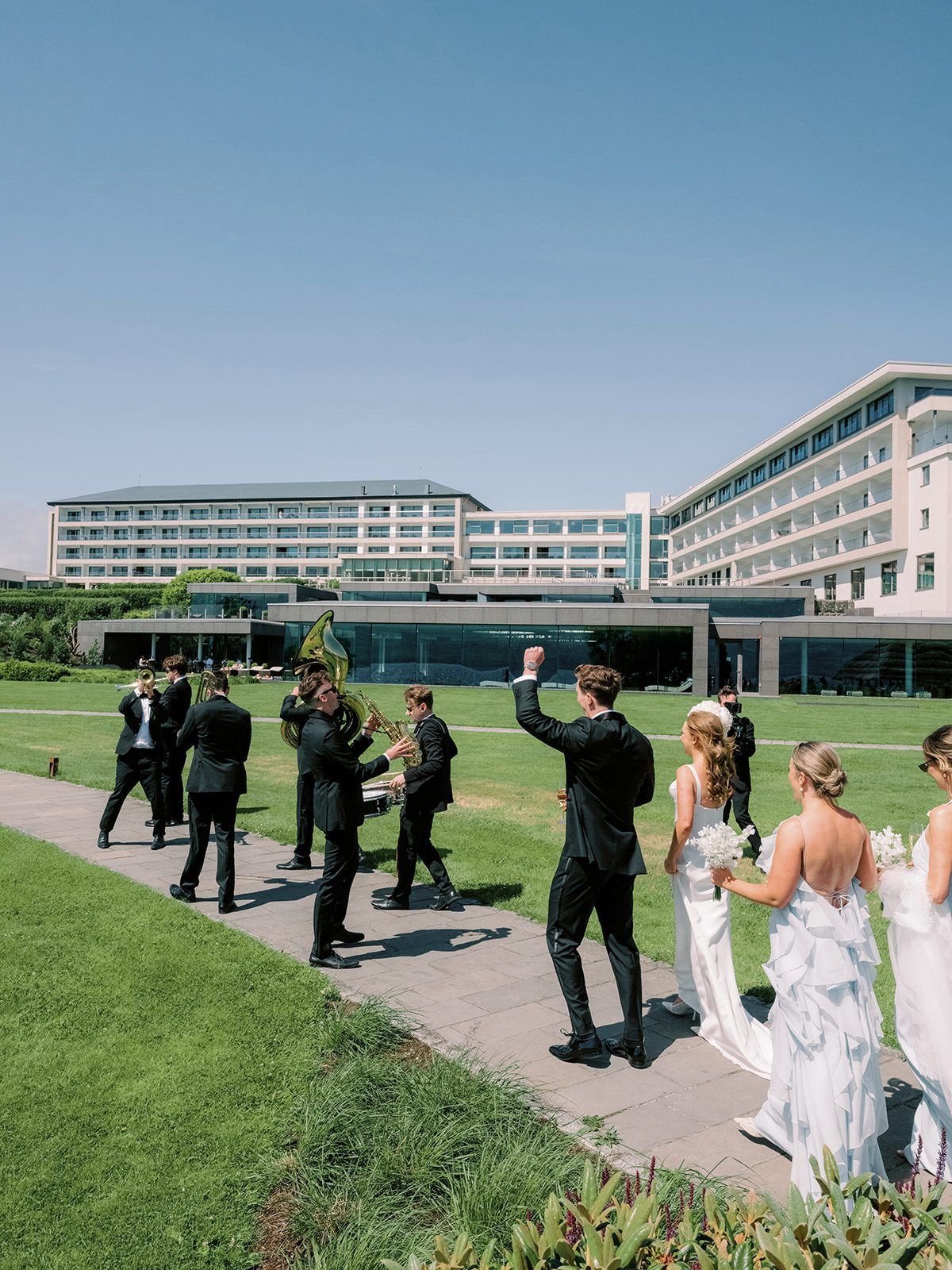 Wedding party cheering as Brasswork plays on the lawn